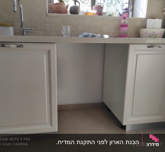 ארונות מטבח לבנים עם משטח עבודה וכיור